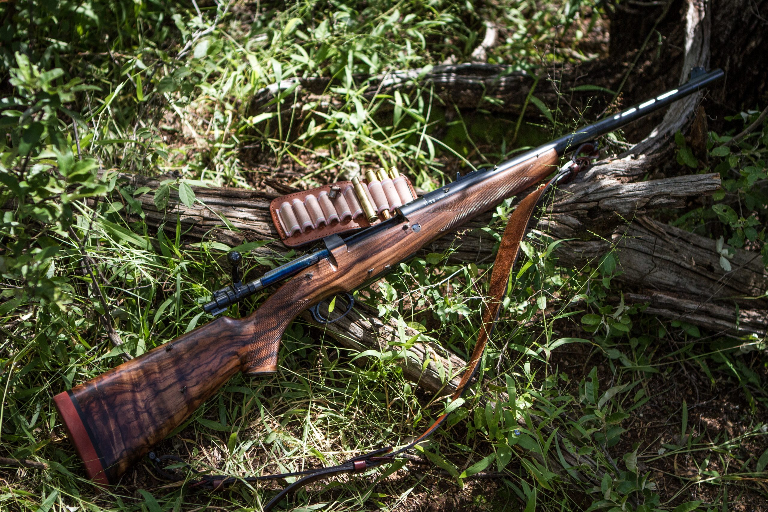 Rifle laying on the ground with bullets