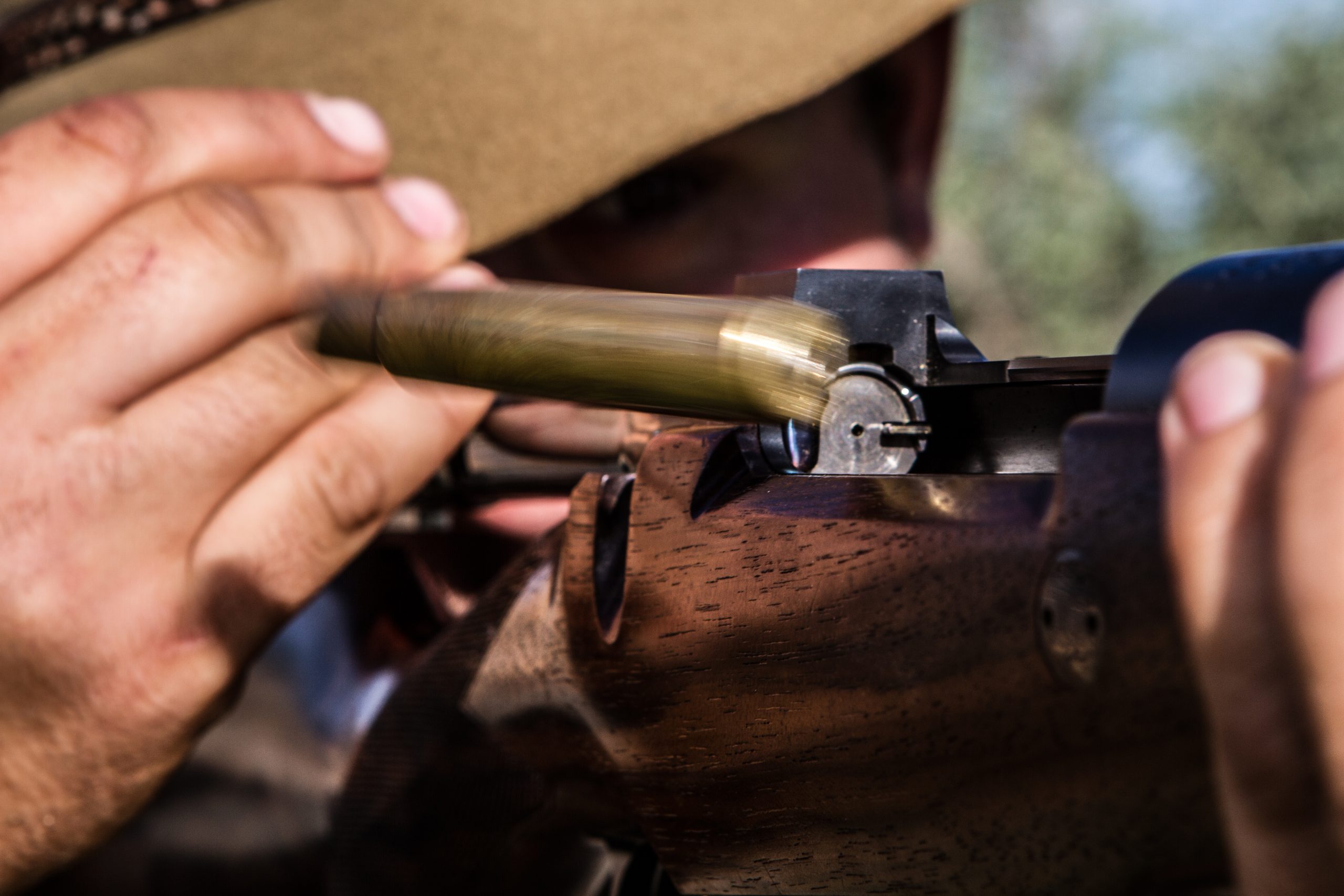 Spent bullet being ejected from the chamber of a rifle