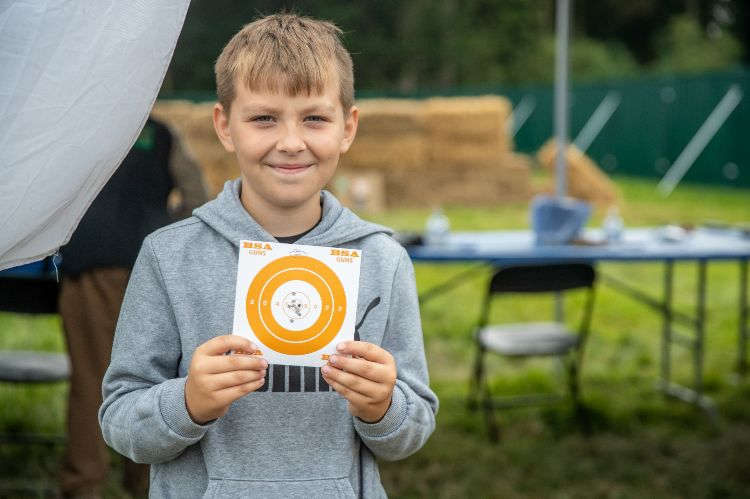 Young boy holding up an airgun target